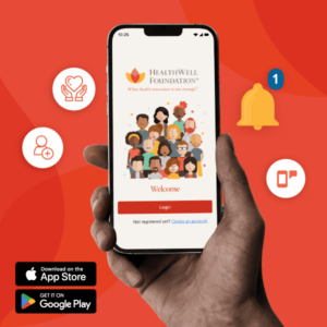 Hand holding a phone showing the login screen for HealthWell Foundation's new phone app.